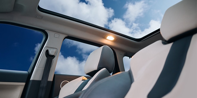 Innenansicht eines Fahrzeugs mit Blick durch das Schiebedach, ausgestattet mit 3M™ Automotive Comfort Solar Film (ACSF).
