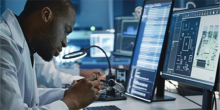 Wissenschaftlerin, die industrielle Verbindungskomponenten inspiziert
