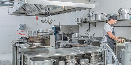 Mann reinigt Industrieküche
