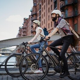 Ein Paar fährt auf elektrischen Fahrrädern in der Nähe der Hamburger Speicherstadt in Deutschland