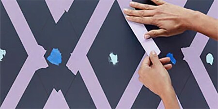 Person, die eine Wand mit 3M-Abdeckband abklebt
