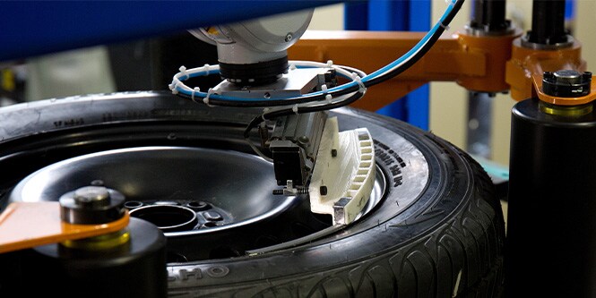 Autoreifen und Rad auf einer Maschine mit 3M Auswuchtgewichten, die angebracht werden

