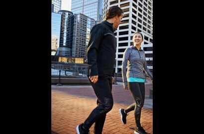 Mann und Frau gehen, reden, trainieren in der Stadt mit 3M Scotchlite C790 Carbon Black Stretch Reflective Material.