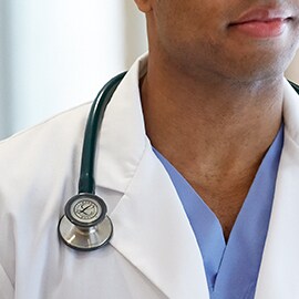 Littmann Stethoskop richtig getragen, so dass es auerhalb des Kragens des weien Arztkittels liegt und die Schluche nicht den Hals des Klinikers berhren.