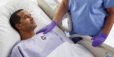 Ein Patient, der ein Bair Hugger Universal-Wärmehemd trägt und sich von einer Operation erholt