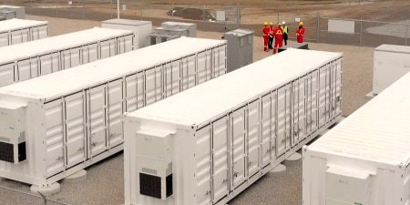 Bild von Arbeitern in der Nähe einer Batteriespeicheranlage
