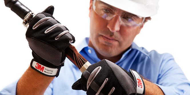 Arbeiter in Schutzkleidung bei der Überprüfung eines Stromkabels
