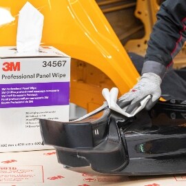 Techniker beim Reinigen der Oberfläche des Ersatz-Karosserieteils