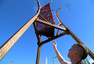 Artist, Philip Blackburn, stands next to his 22-foot kaleidoscope sculpture.
