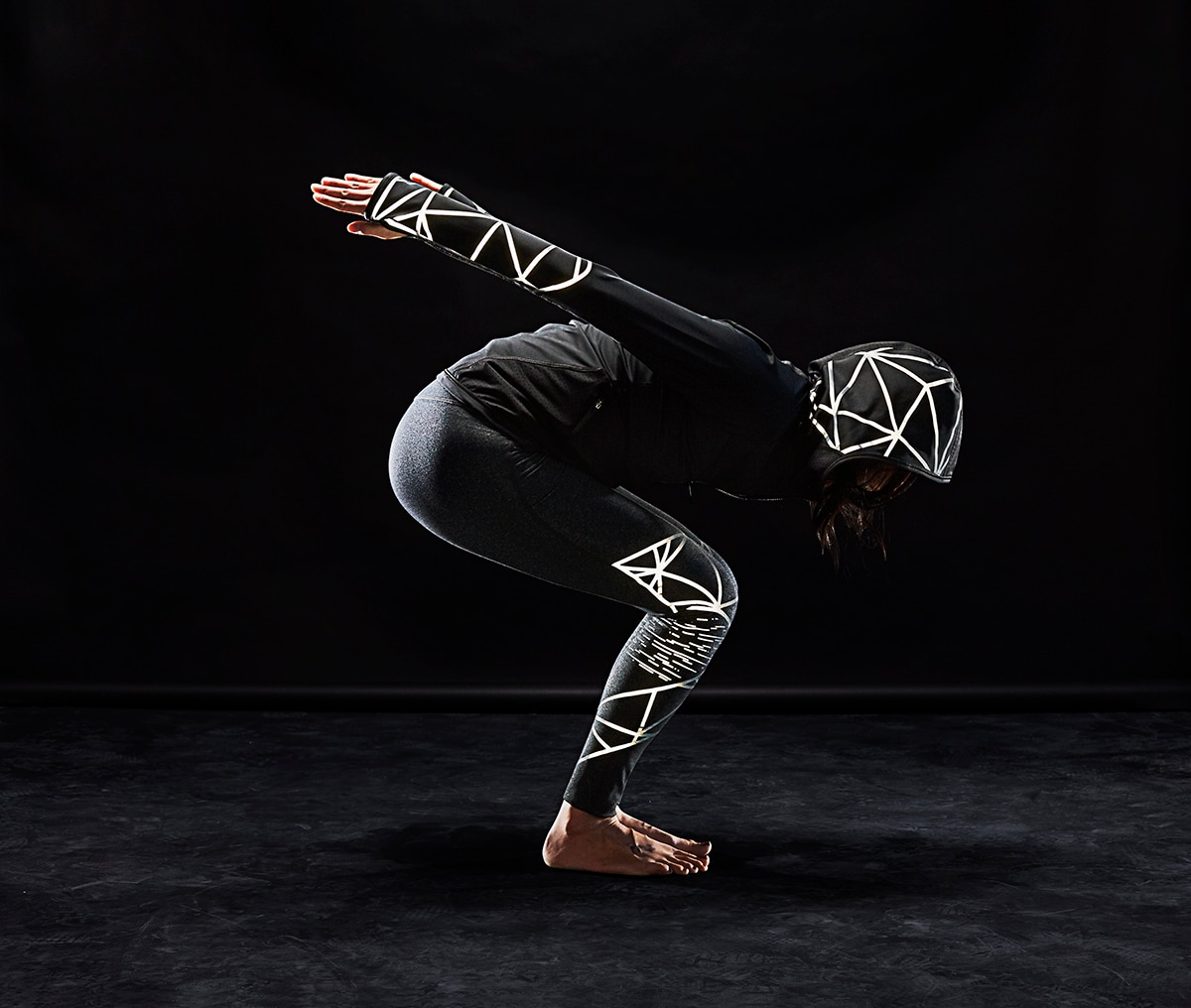Sportliche Frau in Yogapose trägt Sportbekleidung mit beleuchtetem 3M Scotchlite C790 schwarzem reflektierendem Stretchmaterial 