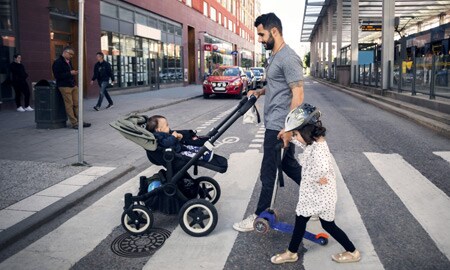 Ein Erwachsener und ein Kind überqueren eine Straße
