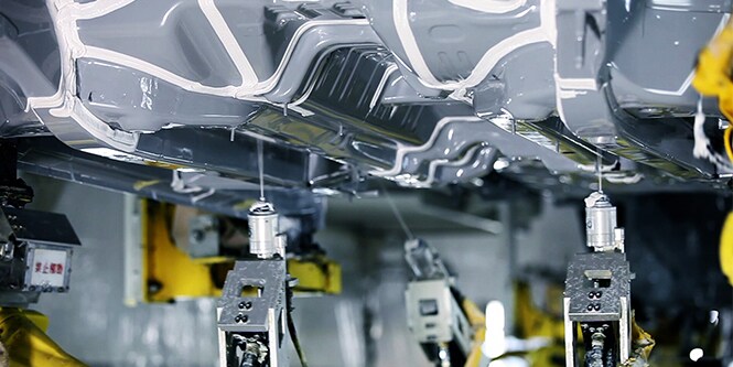 Auf den Unterbodenschutz eines Fahrzeugs wird Seam Sealants aufgebracht.
