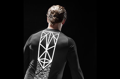 Mann steht in der Dunkelheit, bekleidet mit schwarzem Shirt, beleuchtet von 3M Scotchlite Black Stretch Reflective.