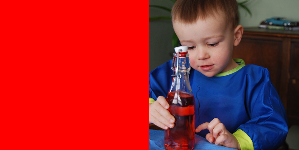 2-year-old William spins a bottle with liquid inside to create a tornado in a bottle.