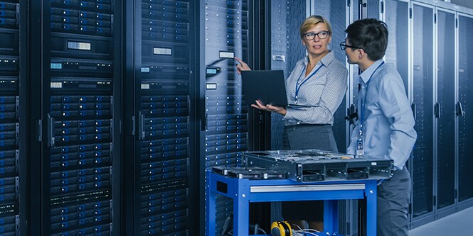 Eine Frau und ein Mann arbeiten in einem Rechenzentrum.
