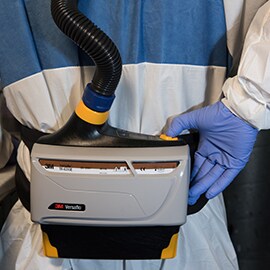 Lackierer in Schutzanzug mit 3M Versaflo Gebläseeinheit TR-800