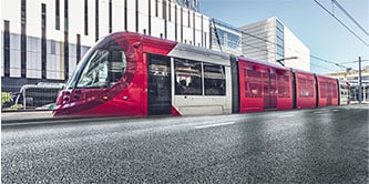 Moderner Zug mit schwarzer und roter Folierung in einem Bahnhof
