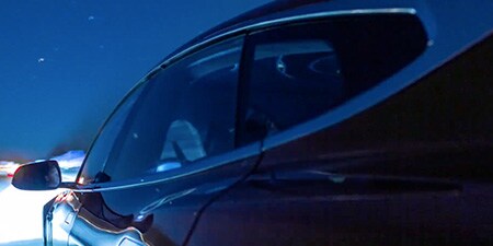 Die Fahrerseite einer Limousine bei Nacht.
