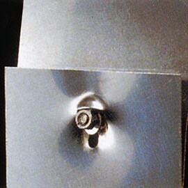 Klebstoffe reduzieren die Spannungskonzentration an Schraub- und Nietpunkten. Bild einer fehlerhaften, mechanisch gefügten Überlappverbindung