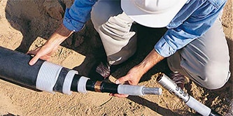 Ein Arbeiter nutzt die 3M™ Kaltschrumpftechnologie für Mittel- und Hochspannungsspleiße
