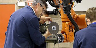 Eine Gruppe von Systemintegratoren programmiert einen Roboter
