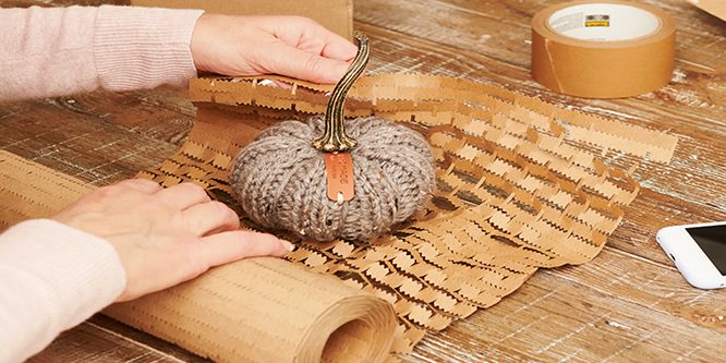 Person, die einen Gegenstand in Scotch® Box Lock™ Cushion Lock Schutzverpackung einwickelt
