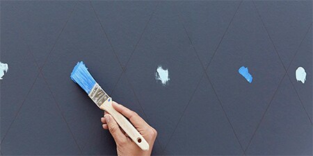 Abbildung einer Person, die mit einer Schablone Farbe an einer Wand aufträgt
