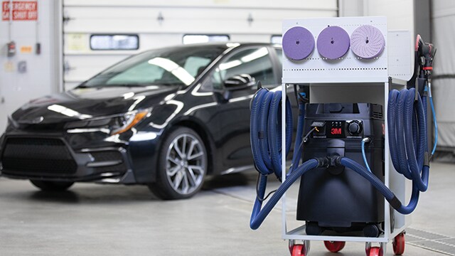 3M Schleif- und Staubabsaugwagen in einer Werkstatt mit einem Auto im Hintergrund
