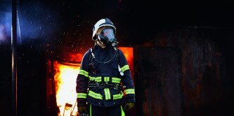 Feuerwehrleute gehen durch ein verrauchtes Gebäude
