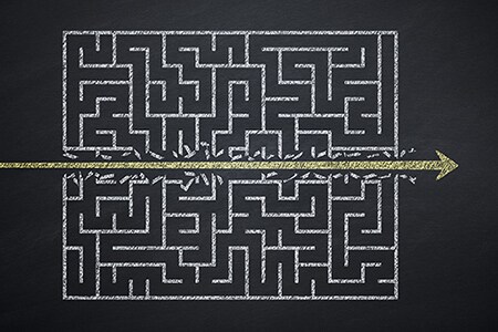 ein durch einen goldenen Pfeil geteiltes Labyrinth
