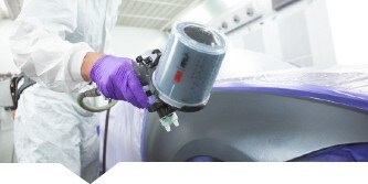 Ein Lackierer lackiert ein Auto mit einer 3M Lackierpistole
