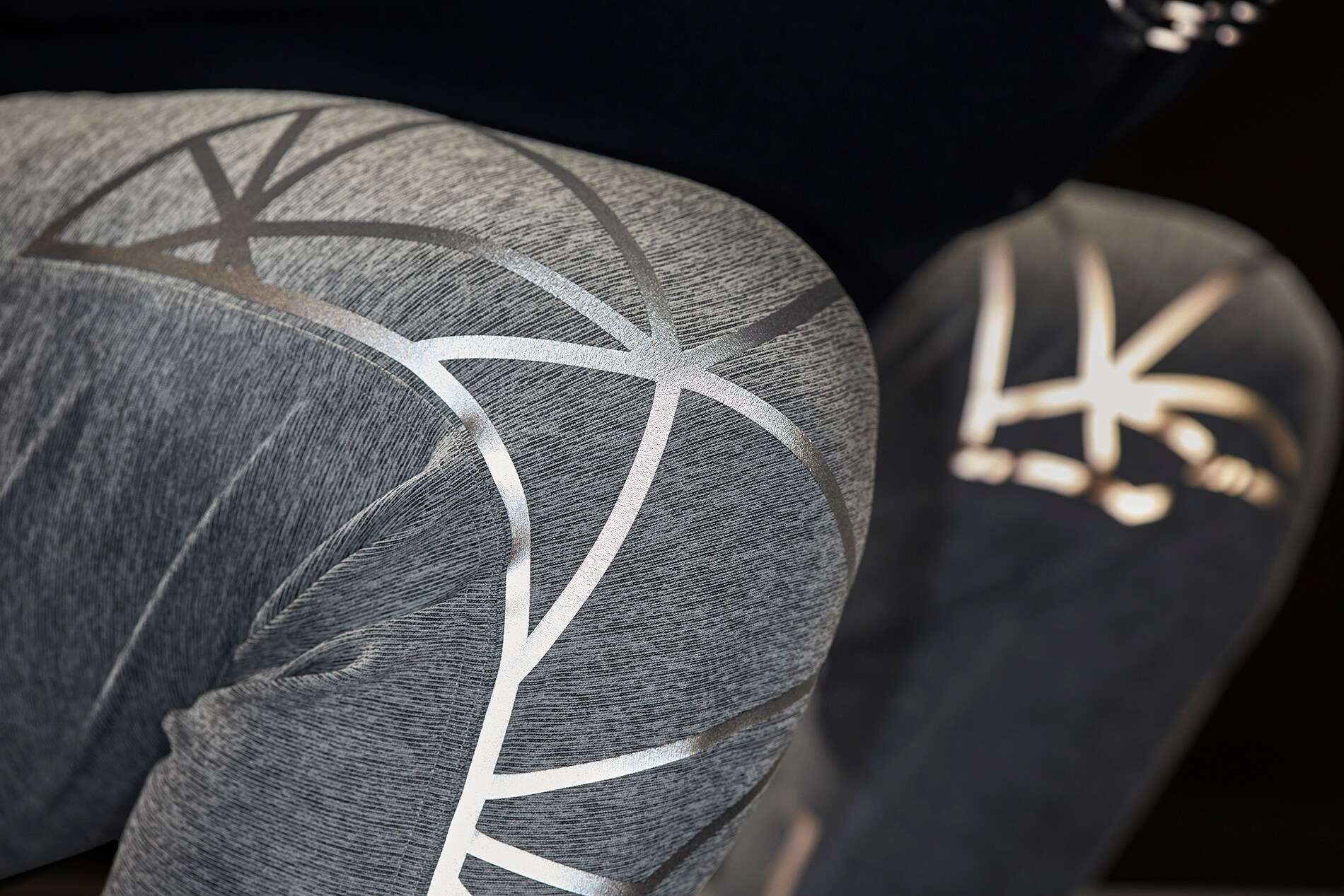 Großaufnahme von beleuchtetem 3M Scotchlite Black Stretch Reflective, das sich über die Knie der Sporthose dehnt.