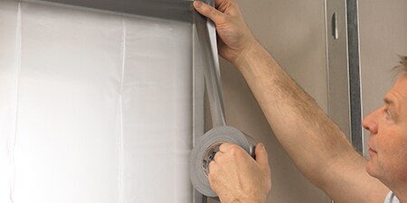 Ein Profi bringt 3M Gewebe- und Reparaturband auf einer Wand an
