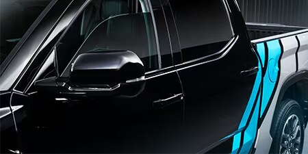 Details einer leuchtend blauen und weißen Akzentfolierung auf einem schwarzen Pickup-Wagen.
