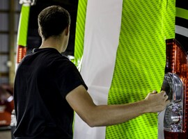 Person, die eine grüne Folie auf einem Lieferwagen verklebt