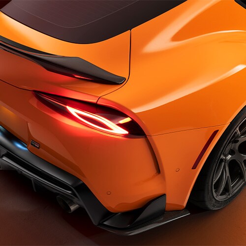 Detail der hinteren Beifahrerseite eines orange folierten Sportwagens 