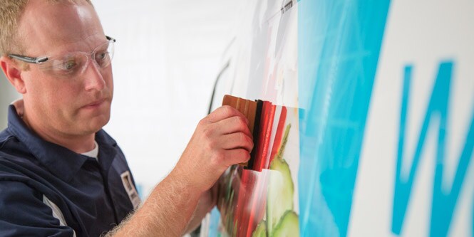 Mann bringt eine Grafikfolie an
