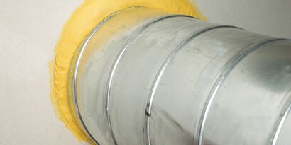 Bild der Einführung eines Lüftungsrohrschlauchs in eine Wand
