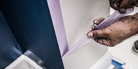 Professioneller Maler beim Abziehen von 3M Abdeckband nach Gebrauch
