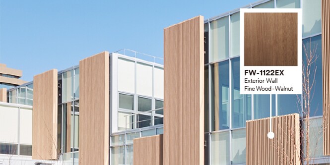 Außenansicht eines Gebäudes mit Glas- und Holzfassade, DINOC EX Folie Walnuss.
