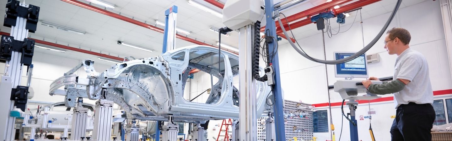 Fabrikarbeiter bei der Installation von Bauteilen an einem Fließband
