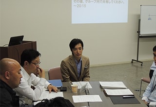 Fujii-san and other employees meet at a conference table so they can work together.