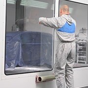 Mann positioniert die Dirt Trap Kabinenschutzfolie an einem Fenster