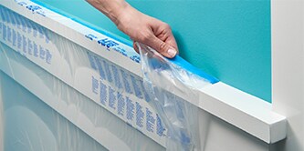 Person, die ScotchBlue™ Abdeckfolien von einer Wand entfernt
