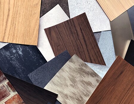 Mehrere Oberflächenveredelungen mit verschiedenen Holzmaserungen, Metalltönen und Mustern.
