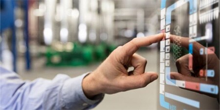 Fabrikarbeiter verwendet ein Touchscreen-Display am Fließband.
