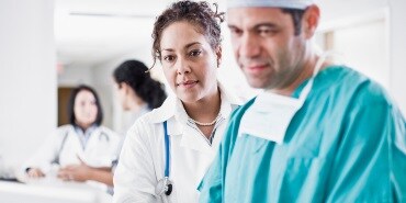A doctor and a nurse are looking at the computer
