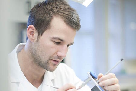 Person, die in einem zahntechnischen Labor arbeitet
