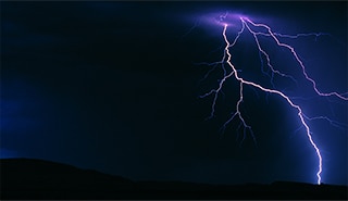 Lightning striking in the night sky.
