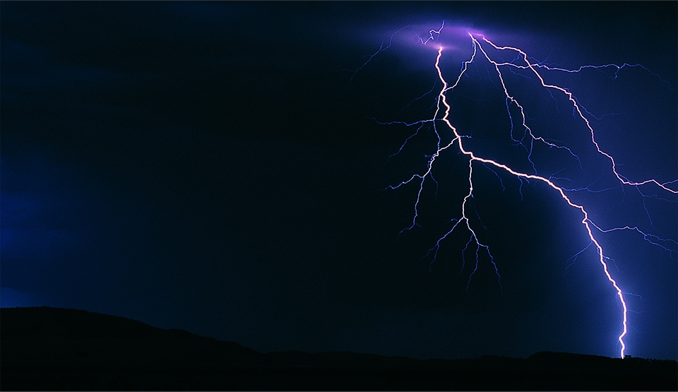 Lightning striking in the night sky.